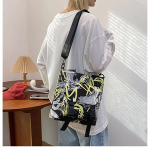 Detail view of large oxford messenger bag with street style graffiti and buckle closure