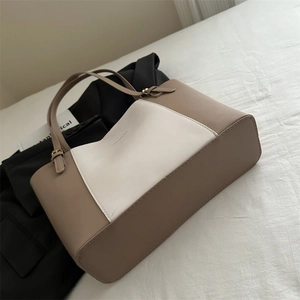 Detail of contrast-color tote bag with beige leather, white panel and gold buckle