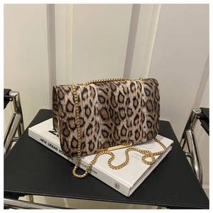 Détail du sac à main imprimé léopard avec bandoulière chaîne dorée sur un livre