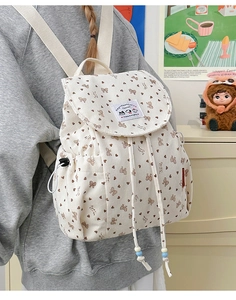 Detail of cream corduroy backpack with bow prints and drawstring bead closure