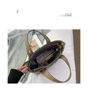 Khaki tote bag showing spacious interior with striped lining and organized storage