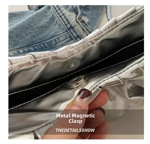 Détail du sac argenté métallisé avec une fermeture à bouton pression magnétique