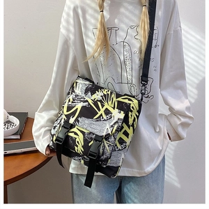 Detailed view of the street style crossbody bag with bold yellow and white graffiti print