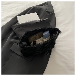 Interior view of black lace handbag showing storage space for phone and cosmetics