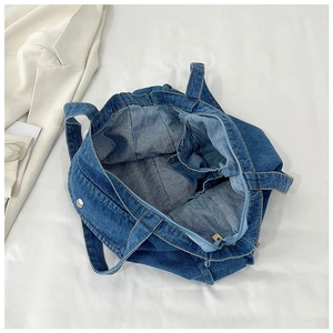 Top view of spacious denim tote bag interior featuring metal zipper and inner pocket