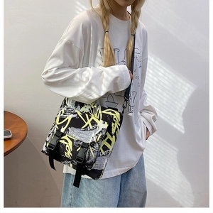 Detail of trendy graffiti oxford messenger bag with dual buckle and adjustable strap