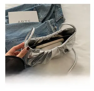 Détail de l'intérieur du sac plissé argenté montrant la capacité pour téléphone