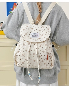 Detail of corduroy backpack with bow prints and cartoon patch on the drawstring cover