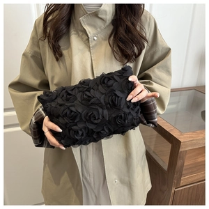 Detailed macro view of 3D mesh rose petals on a chic black evening clutch bag
