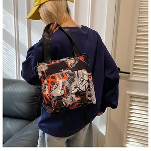 Detail view of graffiti print canvas tote with buckle straps and adjustable side clips