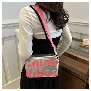 Dettaglio della borsa a tracolla in pelle grigia con lettere Color Vibes rosa e tracolla