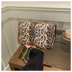 Détail du mini sac léopard avec tissu texturé et bandoulière en chaîne dorée