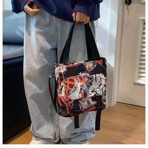 Detail view of large graffiti oxford tote bag showing black and red buckle flap pockets