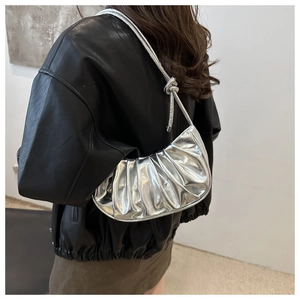 Détails du sac croissant argenté métallisé avec plis élégants et nœud sur la bandoulière
