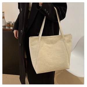 Detail shot of a creamy white crocodile pattern tote bag with large capacity and shoulder straps