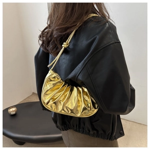 Vue détaillée du sac croissant doré froncé avec un nœud élégant sur la bandoulière