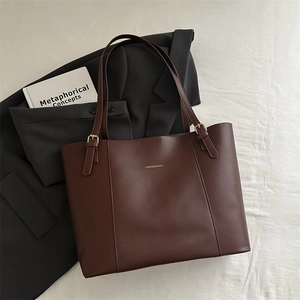 Close-up of brown leather tote bag with gold buckle and Fashion & Bag lettering detail