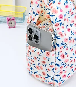 Detailed view of the floral canvas handbag featuring a functional side pocket for a smartphone