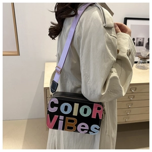Dettaglio borsa a tracolla nera con lettere 3D Color ViBes colorate e tracolla viola