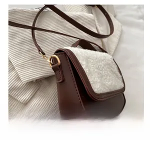 Close-up of the brown faux leather and white shearling detail on this mini crossbody bag