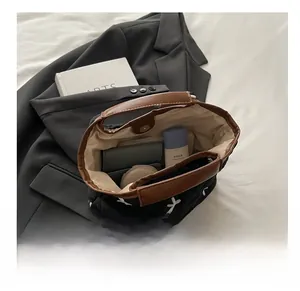 Spacious interior of quilted black handbag showing storage for wallet and cosmetics