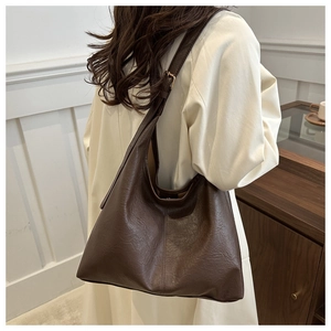 Dettaglio ravvicinato della borsa tote in pelle PU marrone scuro con ampia tracolla