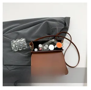 Internal view of brown quilted crossbody bag showing storage for phone and cosmetics
