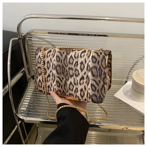 Vue détaillée du sac léopard avec bandoulière chaîne dorée sur un chariot en verre