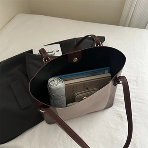 Detail view of large bicolor tote bag showing spacious interior with tablet and daily items