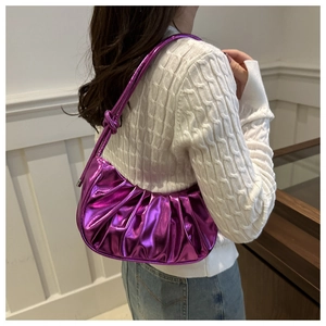 Détail du sac à bandoulière plissé violet métallisé porté avec un pull en tricot blanc