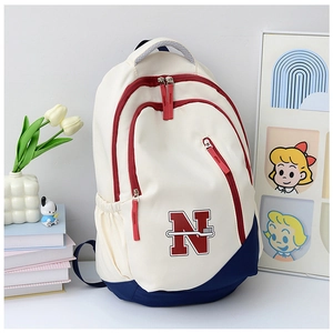 Close-up of stylish color-block canvas backpack with unique red embroidery detail