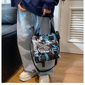 Close-up of graffiti print tote bag with buckle pockets and black canvas straps