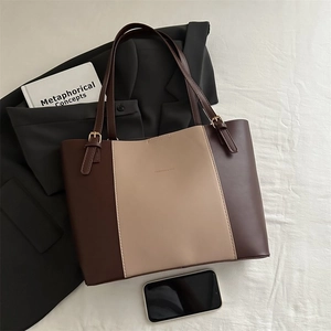 Detail of two-tone tote bag with adjustable straps on a stylish lifestyle background