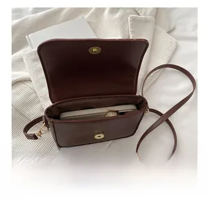 Detail view of brown crossbody bag showing spacious interior fitting a large smartphone