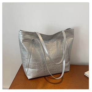 Detailed macro view of silver crocodile embossed texture on a spacious tote bag