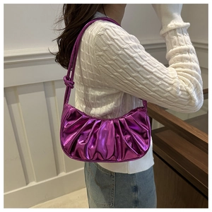 Détail d'un sac sous le bras plissé violet métallisé avec nœud sur la bandoulière