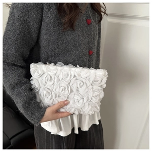 Detail of white organza handbag featuring 3D rose flower texture and top zipper closure