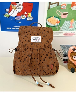 Detailed texture of brown corduroy backpack with cute heart and bow patterns