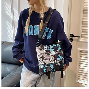 Detail of trendy color-block oxford tote with graffiti print and adjustable buckles