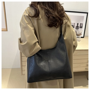 Dettaglio della borsa tote nera minimalista con trama in pelle morbida e cuciture trendy