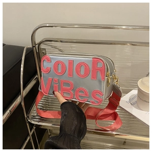 Dettaglio borsa a tracolla argento con scritta rosa COLOR ViBES e finiture metalliche