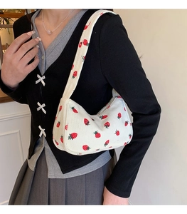 Detailed texture of corduroy material with strawberry patterns and zipper closure