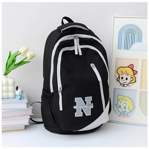 Close-up of black nylon travel backpack showing durable zippers and side mesh pockets