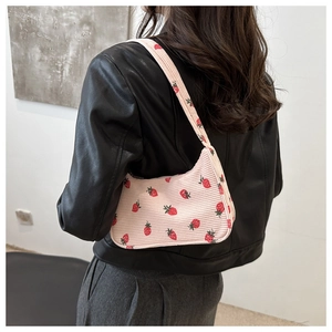 Vue détaillée du sac d'épaule en velours côtelé rose avec motif fraises sur veste en cuir