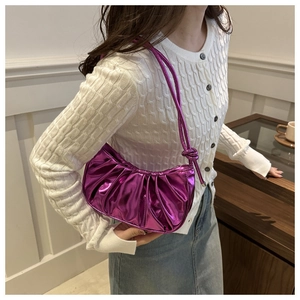 Détail du sac hobo plissé violet métallisé avec bandoulière nouée porté par un mannequin