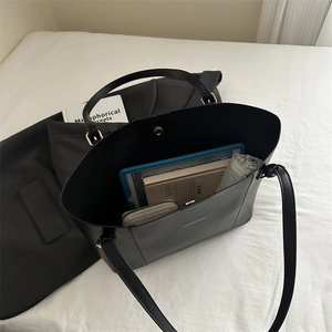 Macro view of a large black tote bag interior showing ample storage for a tablet and books