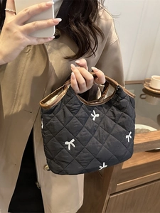Quilted black handbag with white bow embroidery and vintage brown leather trim detailing