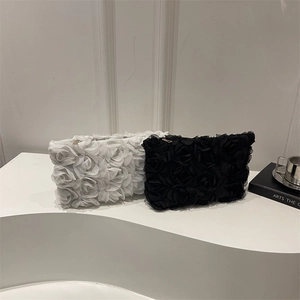 Elegant clutch bag with 3D floral textures in black and white with gold zipper detail