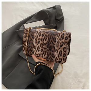 Détail de la texture cuir léopard et de l'élégante bandoulière en chaîne dorée du sac