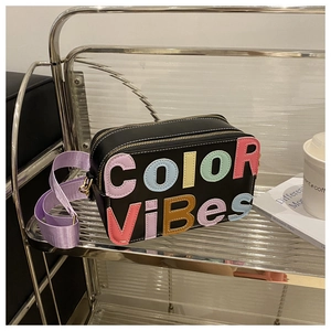 Dettaglio della borsa a tracolla nera con patchwork di lettere COLOR VIBES
